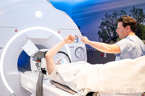 Dr. Leo Sugrue conducting physiological test with patient during essential tumor treatment.