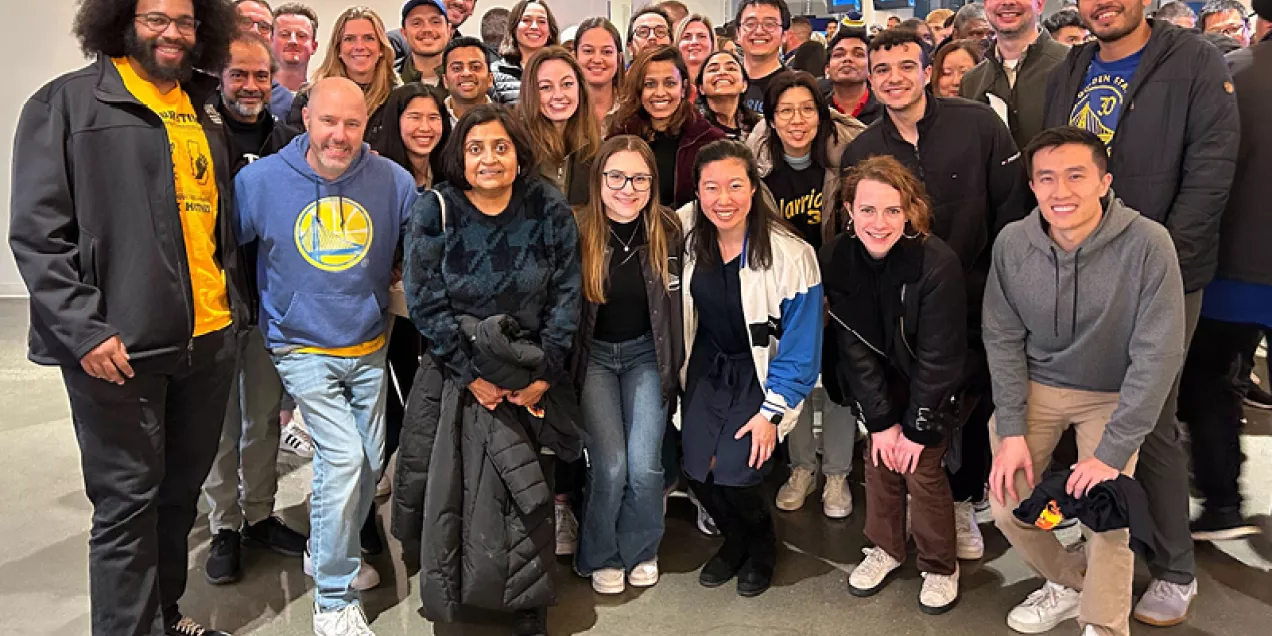 Large group of researchers posing together indoors at a lab or team event
