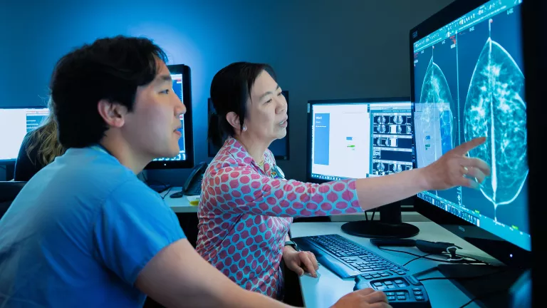 Radiologists reviewing breast imaging scan on the computer.