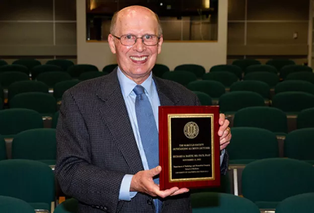 Richard Barth smiling toward the camera, photographed in a formal setting. 