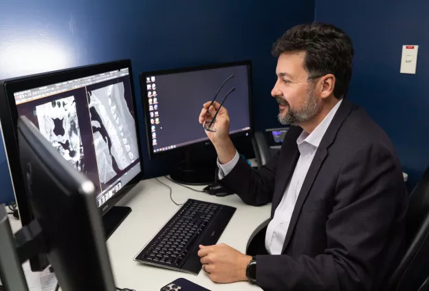 Christopher Hess looking at scans on computer screen