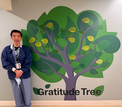 Man standing next to painted tree