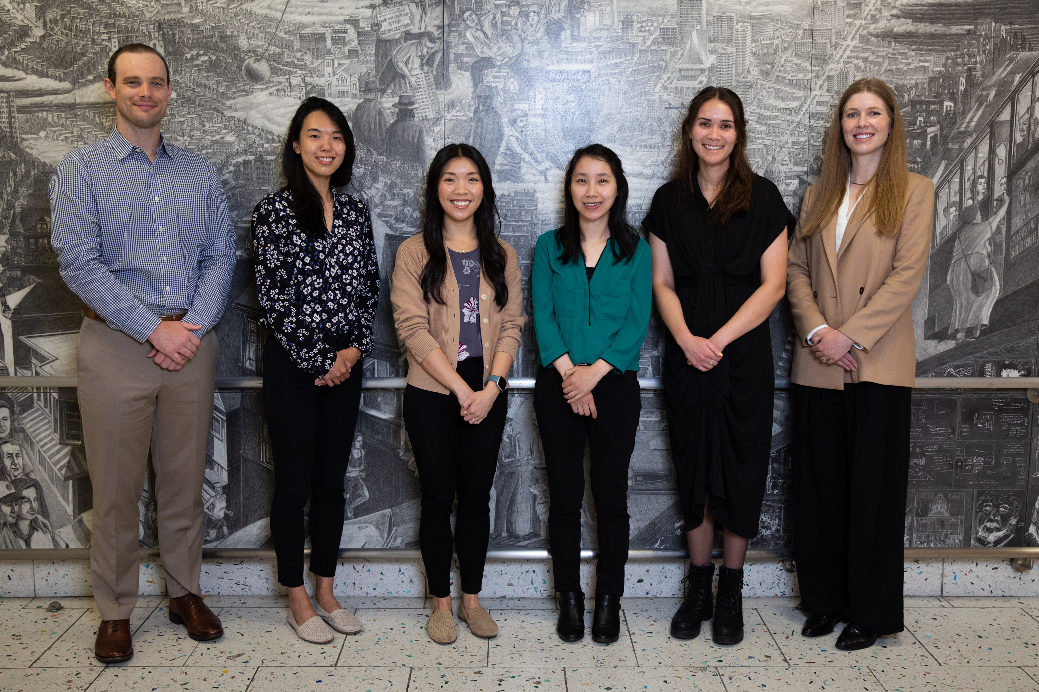 Group photo of the Breast Imaging Fellowship team standing in front of a detailed grayscale mural.
