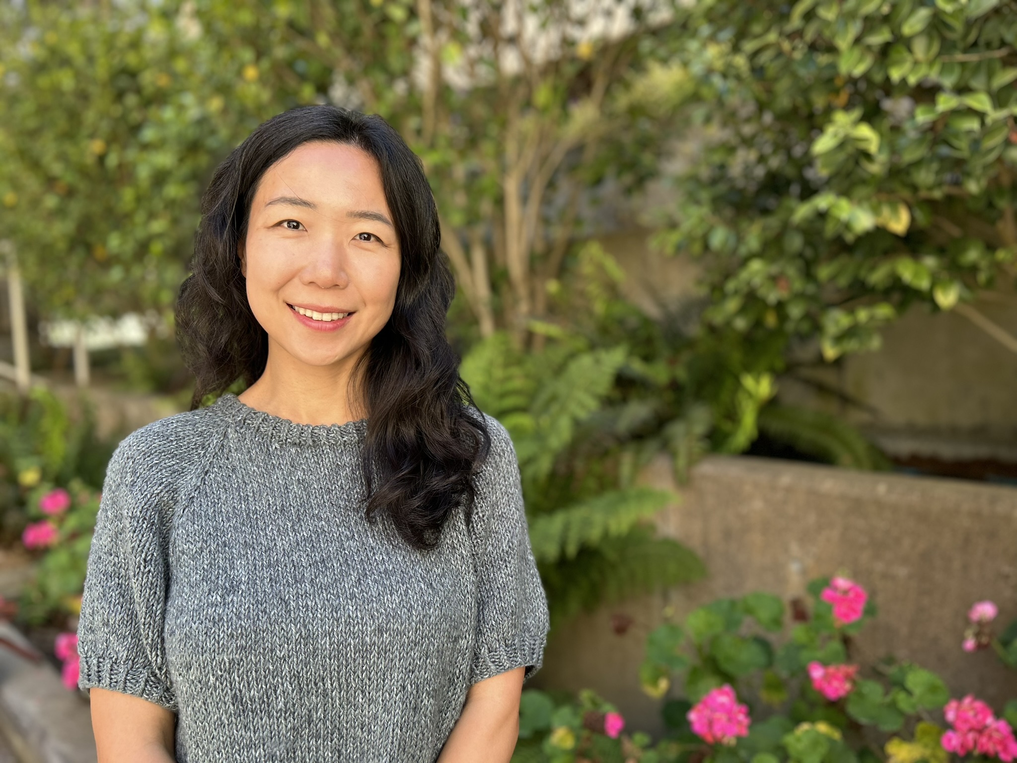 A woman smiling outdoors.