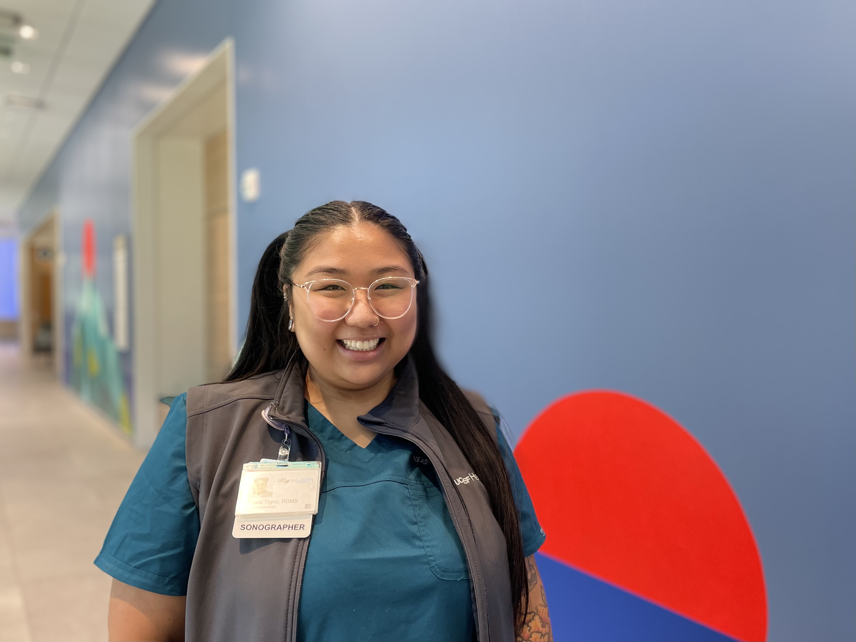 Woman with glasses smiling at Radiology reception at Bayfront Medical Building.