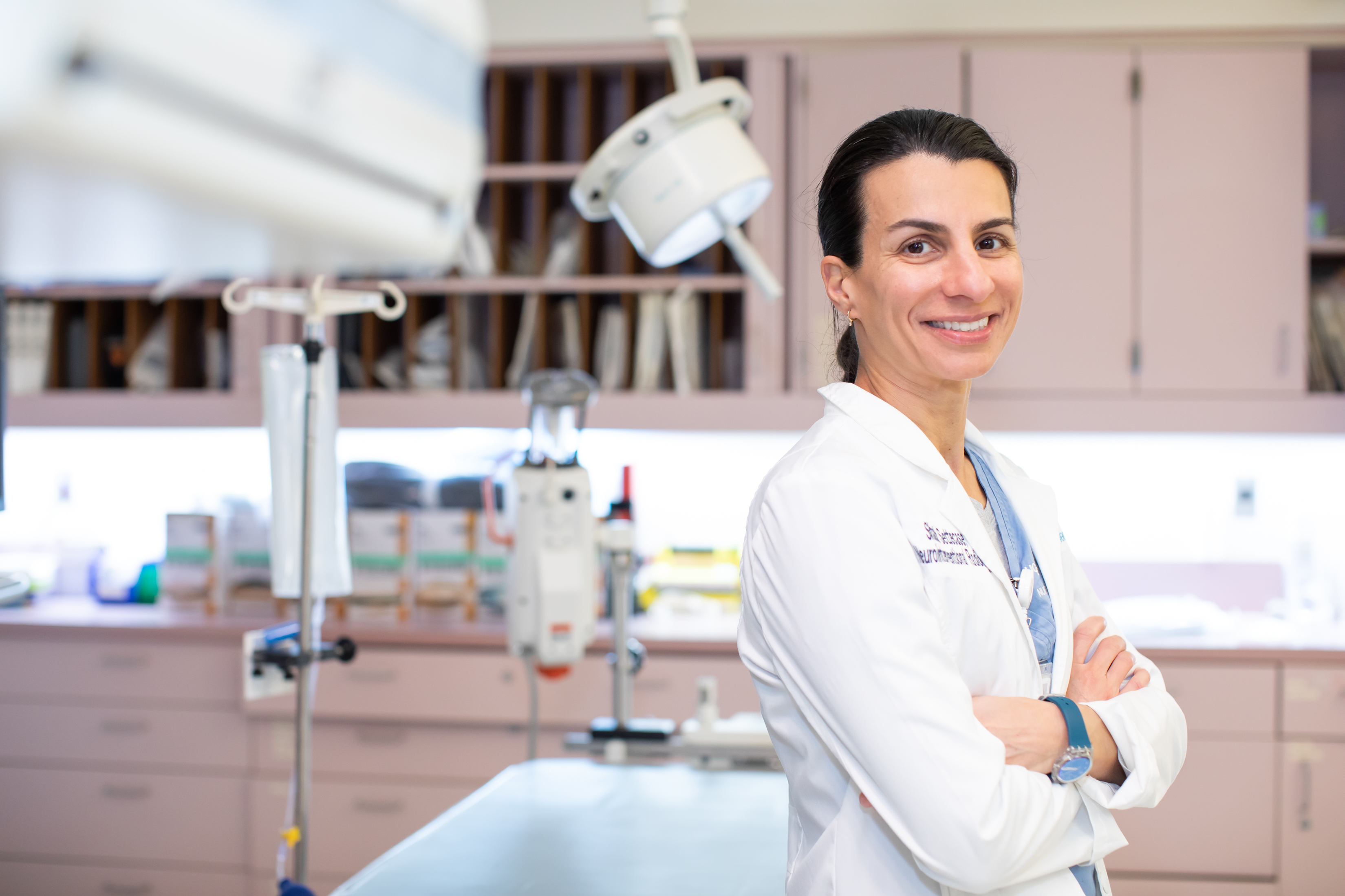 A woman smiling at the camera from a hospital room.