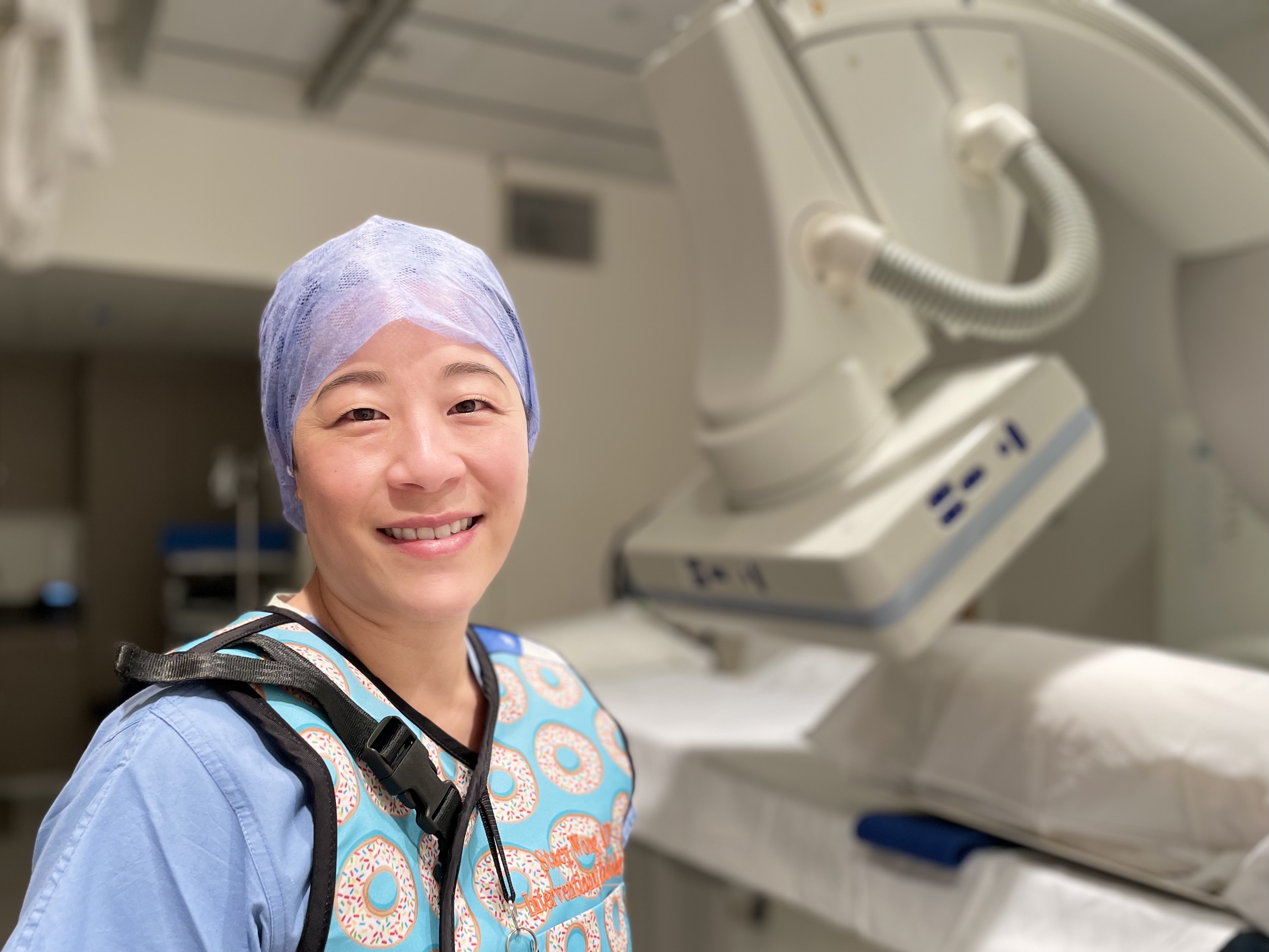 A woman standing in a hospital room.
